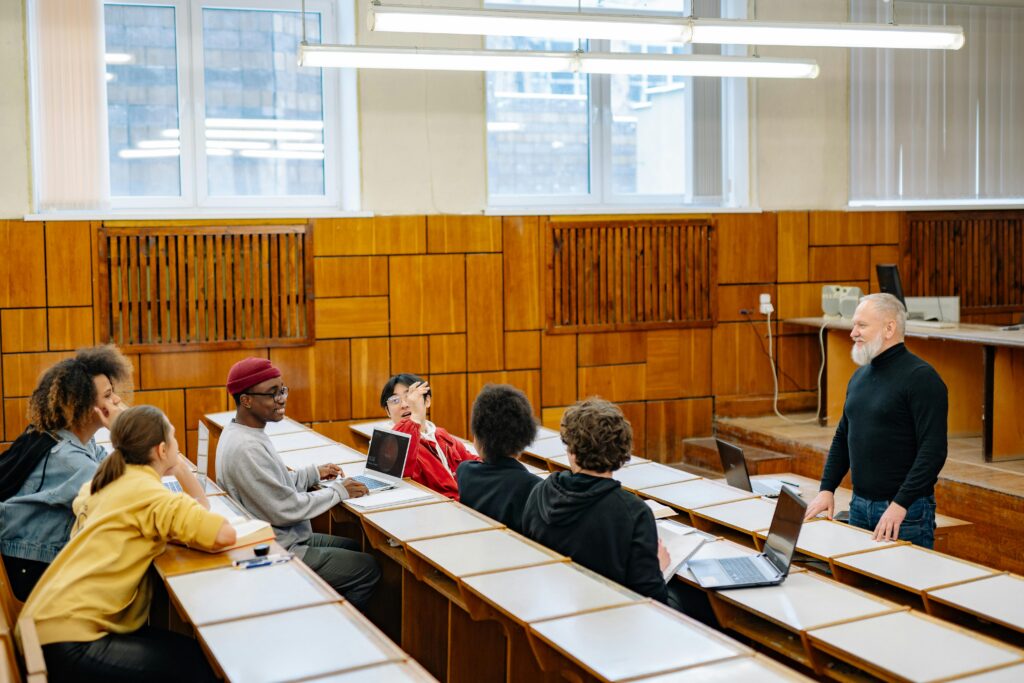 University students in a diverse classroom engaging in a discussion with their professor.